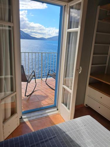 a bedroom with a view of the ocean from a balcony at Asos Luxury Seafront Villas, Kefalonia, 100m beach & center, 4 stars services, Parking - near Myrtos - Fiskardo in Asos