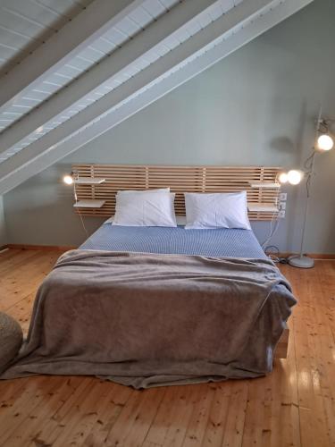 a bedroom with a large bed with a wooden headboard at Asos Luxury Seafront Villas, Kefalonia, 100m beach & center, 4 stars services, Parking - near Myrtos - Fiskardo in Asos