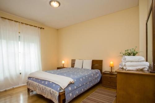 a bedroom with a bed and a dresser and a window at Apartment T3 in Downtown with Sea View in Ponta Delgada