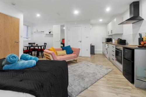 a kitchen and living room with a couch and a table at City Centre Studio Apartments - Riley Apartment - Short Stays UK Ltd in Exeter