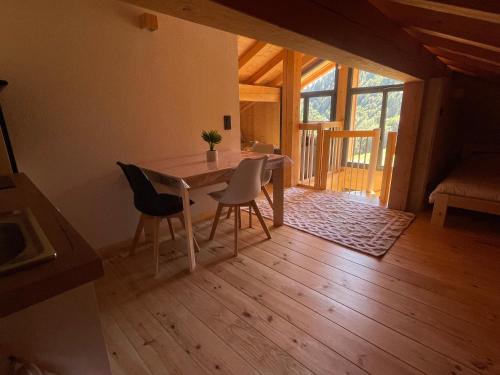 une salle à manger avec une table et deux chaises dans l'établissement Charmant appartement sous combles, neuf, aux Gets