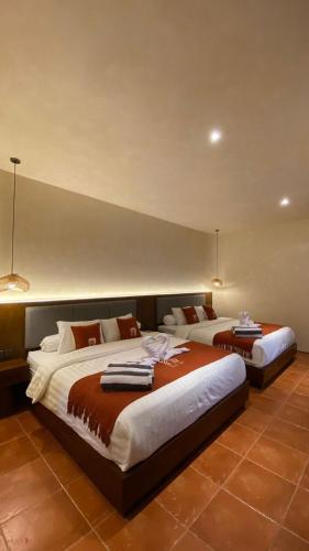 JetisにあるAllure Villa Yogyakartaの部屋にベッドが2つある寝室