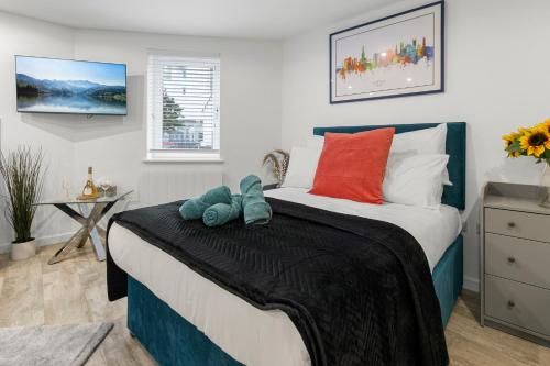 a bedroom with a bed with red and blue pillows at City Centre Studio Apartments - Riley Apartment - Short Stays UK Ltd in Exeter