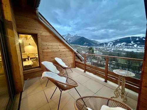 a balcony with chairs and a view of the mountains at Loft Ô Faix in Ancelle
