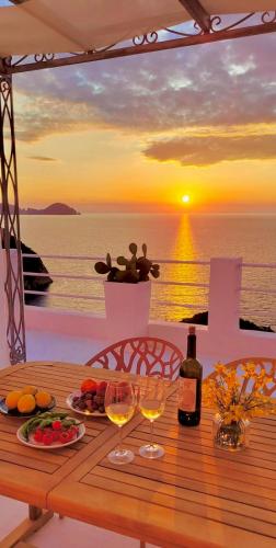 a table with wine glasses and a view of the ocean at PonzaSmeralda Le Forna in Ponza