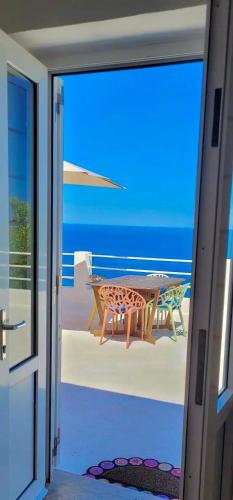 a door open to a patio with a table and the ocean at PonzaSmeralda Le Forna in Ponza