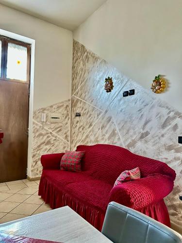 a living room with a red couch in a room at Da Raffaella affittacamere in Cicciano
