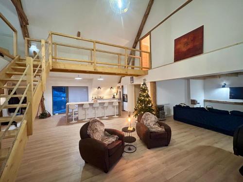 a living room with two chairs and a christmas tree at Loft Ô Faix in Ancelle