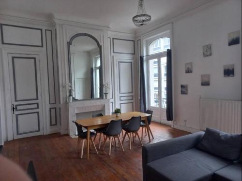 un salon avec une table, des chaises et un canapé dans l'établissement Spacieux no6 Carnot beau T3 direct métro, à Tourcoing