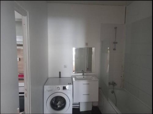 une salle de bain blanche avec une machine à laver et un lavabo dans l'établissement Spacieux no6 Carnot beau T3 direct métro, à Tourcoing