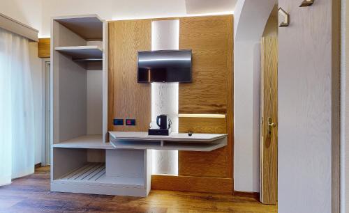 a bathroom with a sink and a tv on a wall at Hotel Madonna delle Nevi in Folgarida