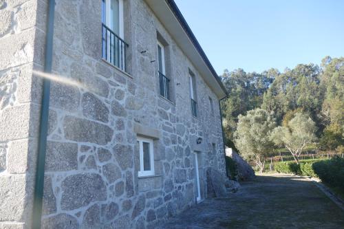 a side of a stone building with a window at Casa nos Penedos in Arcos de Valdevez