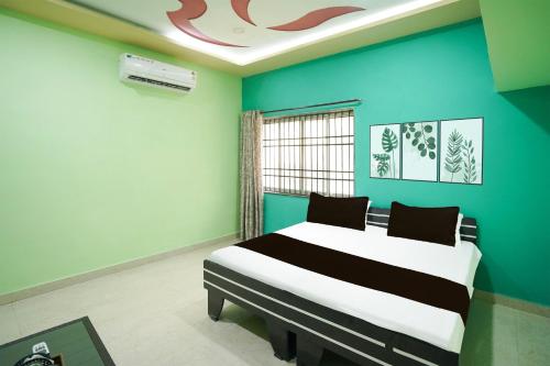 a bedroom with a bed and a blue wall at Hotel O Happy Hotel in Raipur