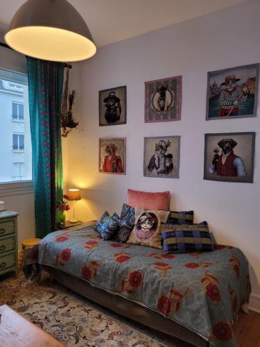 - une chambre dotée d'un lit avec des photos sur le mur dans l'établissement Appartement cosy et lumineux 1 à 3 personnes, à Caen