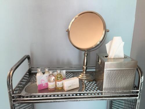 a metal shelf with a mirror and other items on it at Beach Bungalow Inn and Suites in Morro Bay