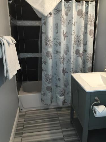 a bathroom with a sink and a shower curtain at Beach Bungalow Inn and Suites in Morro Bay