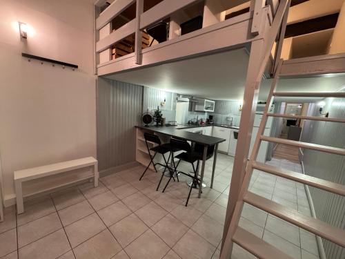 Cette chambre comprend une mezzanine avec une table et une cuisine. dans l'établissement Au pied des Halles - 46m2 en centre ville - 1 chambre et 1 mezzanine - tout confort, à Sète