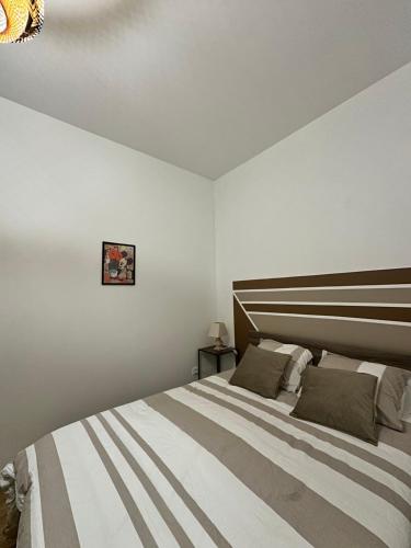 a bedroom with a large bed with a wooden headboard at Casa Armando, beau F2, 2 places de parking clos, proche Disneyland in Quincy-Voisins