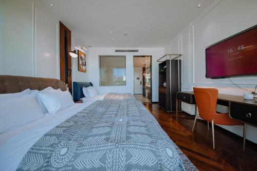 a bedroom with a large bed with a flat screen tv at Lakeside Retreat - LuguLake Lijiang in Zuosuo