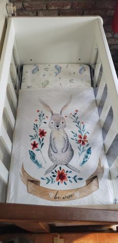 a crib with a pillow with a rabbit on it at Chalet 176, Durbuy PROMO in Durbuy