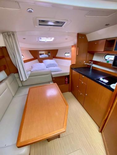 une petite chambre avec une table dans un bateau dans l'établissement BOAT PARADISE LA ROCHELLE - Bavaria 31 Sport, à La Rochelle