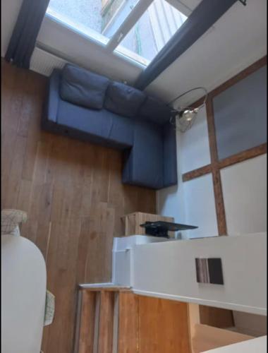 un salon avec un canapé bleu et une fenêtre dans l'établissement Joli T3 no4 Motte Parking, à Tourcoing