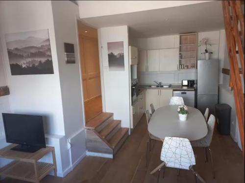 une cuisine et une salle à manger avec une table et une télévision dans l'établissement Joli T3 no4 Motte Parking, à Tourcoing