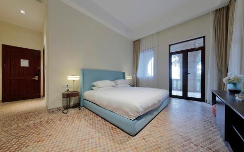 a large bedroom with a bed and a door at Linggan Linghai Hotel in Xiamen