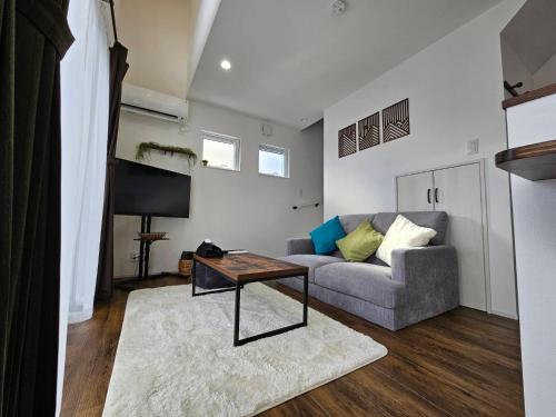 a living room with a couch and a table at Onasyas-A in Hakodate