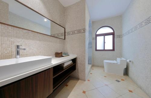 a bathroom with a sink and a toilet at Linggan Linghai Hotel in Xiamen