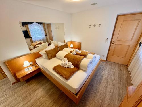 a large bedroom with a large bed and a mirror at Residence Palmai in Ortisei
