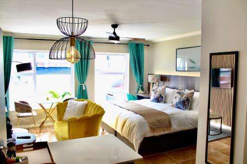 Un dormitorio con una cama, un escritorio y una silla. en Yellow Couch Studio Apartment 1 KingBed, en Ciudad del Cabo