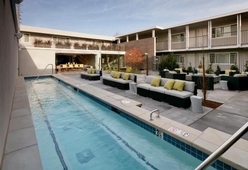 una piscina con sofás y un hotel en Hotel Lucent, en Menlo Park