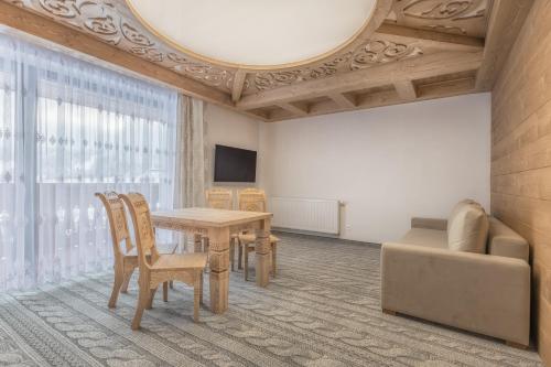a living room with a table and a couch at Apartmány Dominek in Ždiar