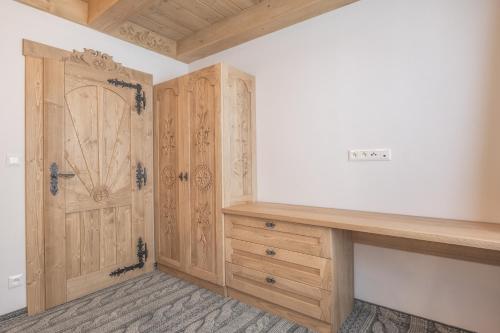 a room with a wooden cabinet and a door at Apartmány Dominek in Ždiar