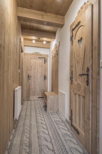 a bathroom with a wooden door and a tile floor at Apartmány Dominek in Ždiar