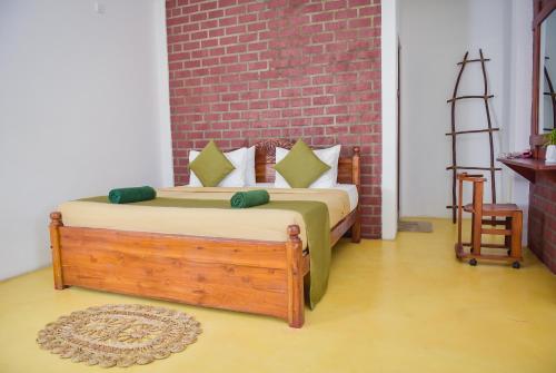 a bedroom with two beds and a brick wall at The Residence Ella in Ella