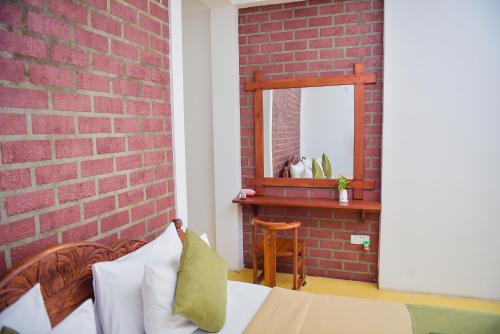 a bedroom with a brick wall and a bed with a mirror at The Residence Ella in Ella