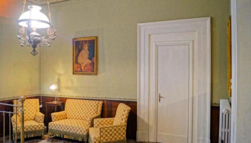 a living room with two chairs and a chandelier at Historical Suites VVM in Lecce