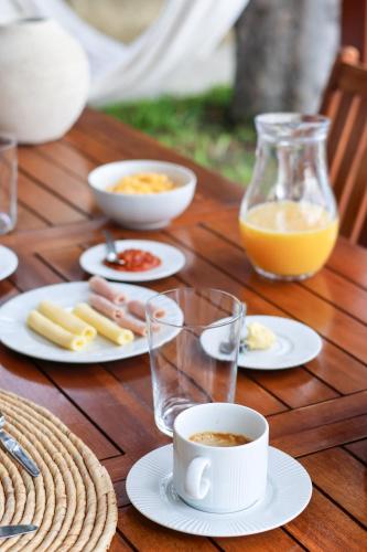 a wooden table with plates of food and a cup of coffee at Seashore Villa - Porto Santo in Porto Santo