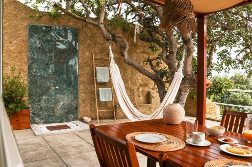 a wooden table with a hammock on a patio at Seashore Villa - Porto Santo in Porto Santo