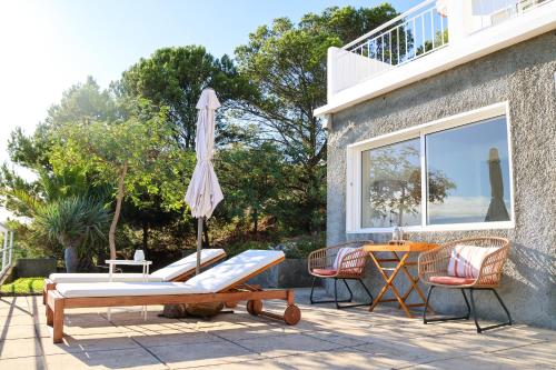 a patio with a table and chairs and an umbrella at Seashore Villa - Porto Santo in Porto Santo