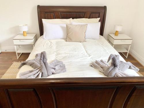 a bed with blankets and towels on it with two night stands at Urba Luxury 3 Bed Stays Sheffield Central in Sheffield