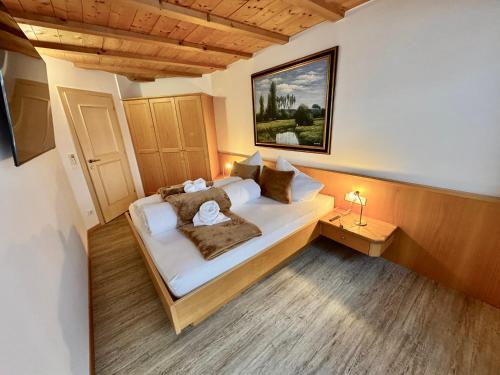 a bedroom with a large bed with pillows at Residence Palmai in Ortisei