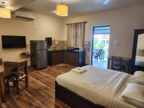 a bedroom with a bed and a kitchen with a table at Coastal Suites Apart Hotel ---- 8 minutes walk to beach in Benaulim