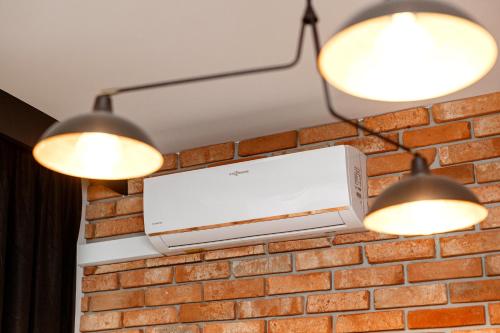 two lights hanging from a brick wall with a computer on it at Ratusz Apartment Centrum in Głogów