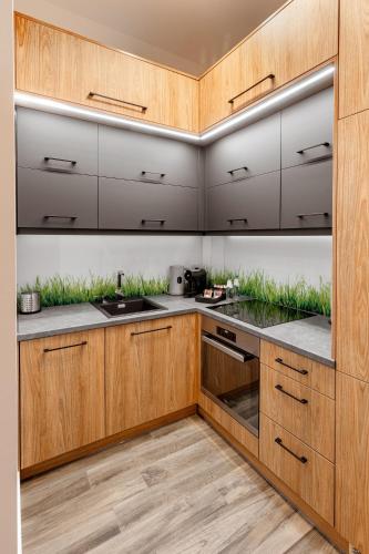 a kitchen with wooden cabinets and stainless steel appliances at Ratusz Apartment Centrum in Głogów