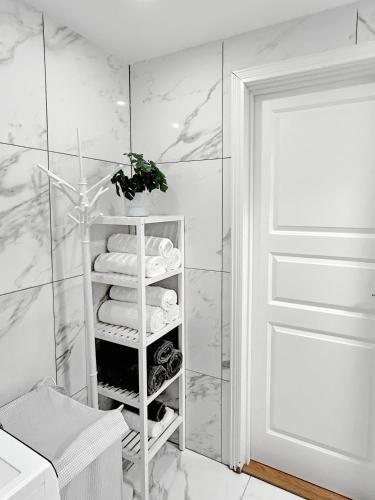 a bathroom with a white towel rack with towels at Lyxig Stadsro och Utrymme villa i Malmö in Malmö
