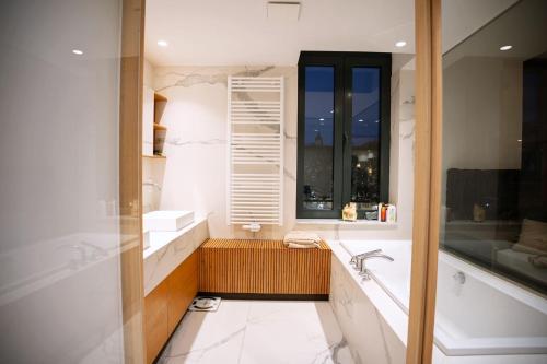 une salle de bain avec une baignoire et un lavabo dans l'établissement Dream Saint Lambert, à Liège