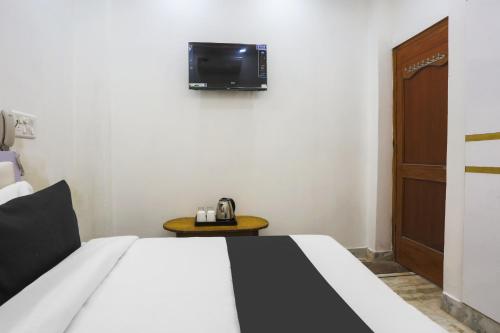 a bedroom with a bed and a tv on the wall at Hotel O Golden Key Rohini in New Delhi